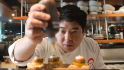Peruvian Nikkei chef Mitsuharu Tsumura, known as Misho, places the final touches on a dish of his creation at the Maido high-cuisine restaurant in Lima on June 17, 2016. Maido, welcome in Japanese, has jumped from 44 to 13 in the 2016 list of the top 50 restaurants in the world. It was the biggest rise of the year, which also made it the world's best Nikkei restaurant in the world. The term Nikkei identifies the Japanese emigrants from Japan and their descendants that reside in a foreign country. / AFP / CRIS BOURONCLE (Photo credit should read CRIS BOURONCLE/AFP via Getty Images)