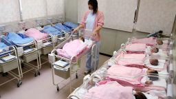 Hospital staff attend to babies in the nursery ward of the Hospital in Misato city, Saitama prefecture, Japan.