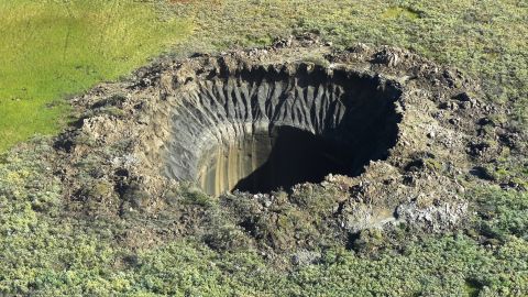 An aerial view from onboard a helicopter taken on August 25, 2014 shows a crater on the Yamal Peninsula, northern Siberia. Russian scientists have now discovered seven giant craters in remote Siberia, the deputy director of the Oil and Gas Research Institute of the Russian Academy of Sciences, Vasily Bogoyavlensky, told AFP on March 12, adding that the mysterious phenomenon was believed to be linked to climate change.