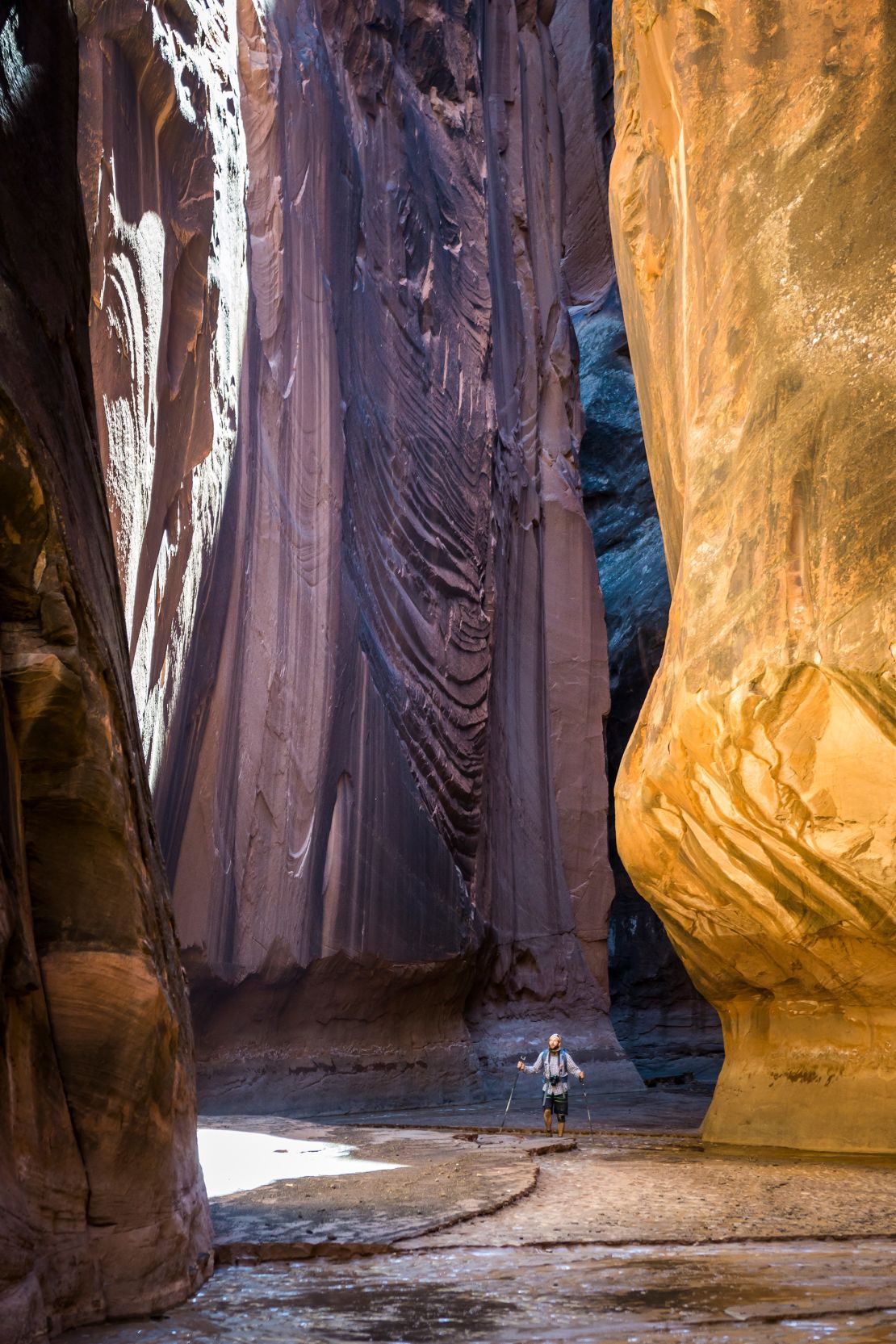 A hiker at the bottom of Buckskin Gulch offers a sense of its depth.