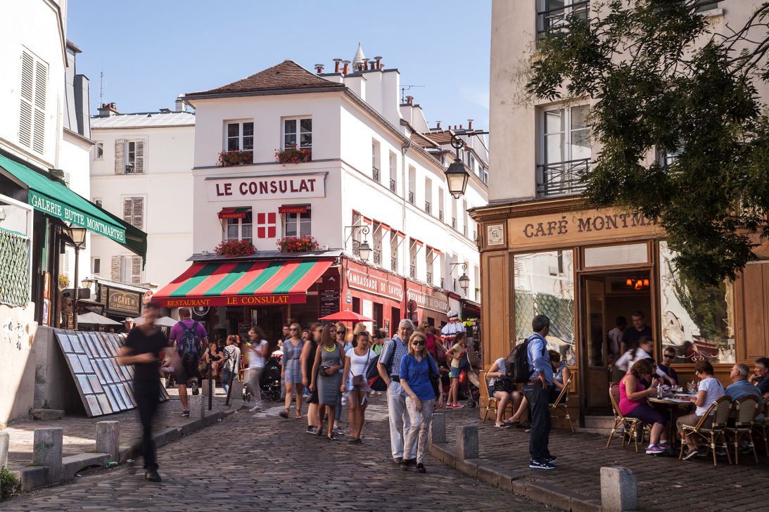 The lively streets of Paris's Montmartre district attract tourists of various nationalities.