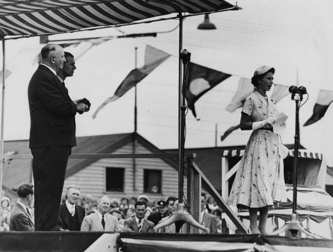 Queen Elizabeth II speaks to the servicemen from the stage, watched by the Duke of Edinburgh (behind, right) at Newcastle Sports Ground, Australia, on February 9, 1954.