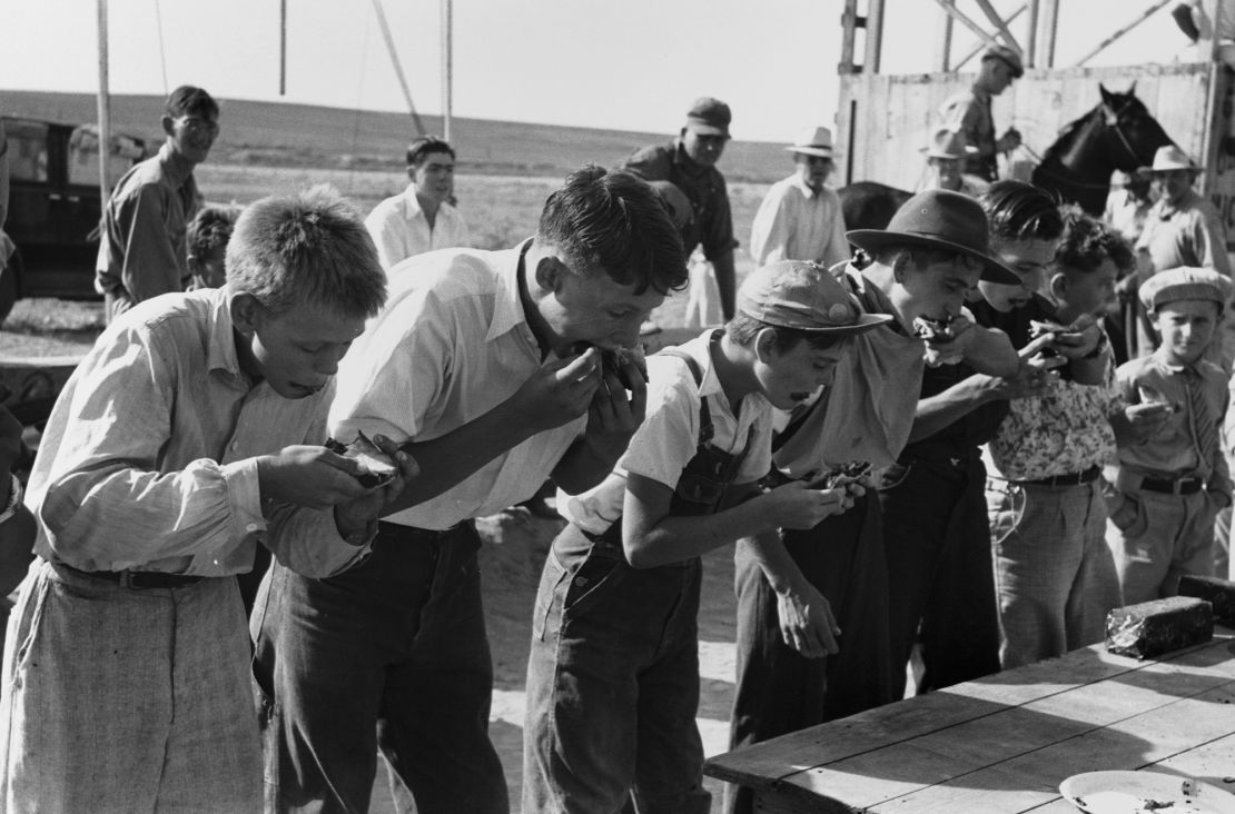 Boys participating in a pie eating contest at the 4-H Club fair in Cimarron, Kansas. August 1939.