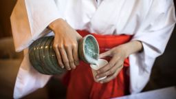 A Japanese attendant pours sake into a cup for visitors at the Koami Shinto shrine during the doburoku (sake) festival in Tokyo on November 28, 2016. 
Every year on November 28, Shinto shrines hold the festival to give out free sake, which is made from freshly harvested rice of the year, as part of a Shinto tradition to thank gods for the autumn harvest. / AFP / Behrouz MEHRI        (Photo credit should read BEHROUZ MEHRI/AFP via Getty Images)