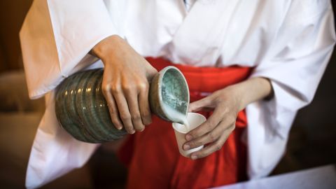 A Japanese attendant pours sake into a cup for visitors at the Koami Shinto shrine during the doburoku (sake) festival in Tokyo on November 28, 2016. 
Every year on November 28, Shinto shrines hold the festival to give out free sake, which is made from freshly harvested rice of the year, as part of a Shinto tradition to thank gods for the autumn harvest. / AFP / Behrouz MEHRI        (Photo credit should read BEHROUZ MEHRI/AFP via Getty Images)