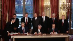 Leaders of six other nations look on as the Presidents of Serbia, Croatia, and Bosnia sign the Dayton Peace Accords at the Elysee Palace in France on December 14th, 1995.