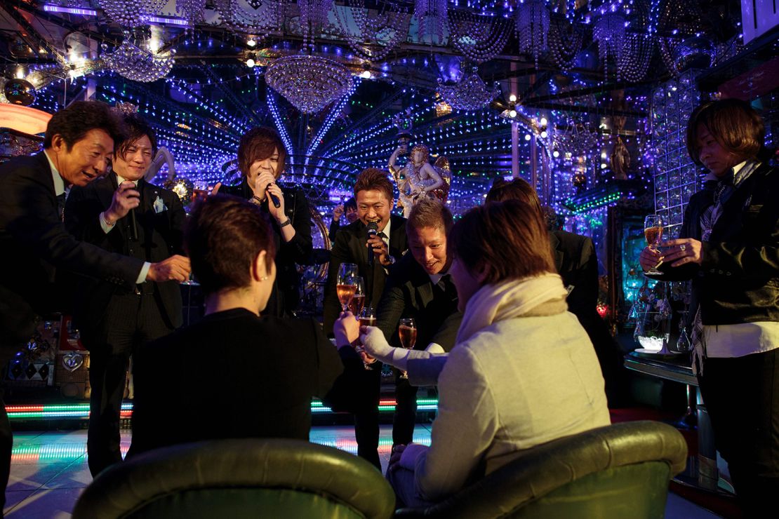 Male hosts drink champagne with a customer in a host club in Kabukicho, Tokyo, in January 2017.