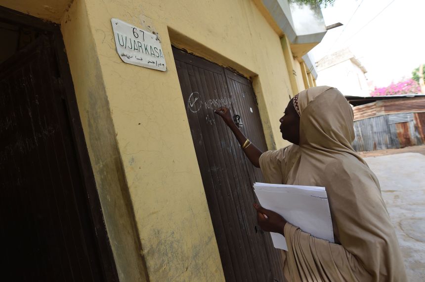 A health worker marks the gate of a house visited as part of a vaccination campaign against polio in Nigeria.