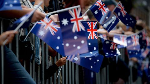 TOPSHOT - People wave Australian flags as they watch the Anzac Day parade in Sydney on April 25, 2017. - Ceremonies are held annually on the April 25 anniversary of the ill-fated 1915 landing of the Australian and New Zealand Army Corps in modern-day Turkey during World War I, known as Anzac Day. (Photo by PETER PARKS / AFP) (Photo by PETER PARKS/AFP via Getty Images)