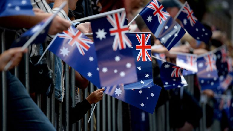 TOPSHOT - People wave Australian flags as they watch the Anzac Day parade in Sydney on April 25, 2017. - Ceremonies are held annually on the April 25 anniversary of the ill-fated 1915 landing of the Australian and New Zealand Army Corps in modern-day Turkey during World War I, known as Anzac Day. (Photo by PETER PARKS / AFP) (Photo by PETER PARKS/AFP via Getty Images)