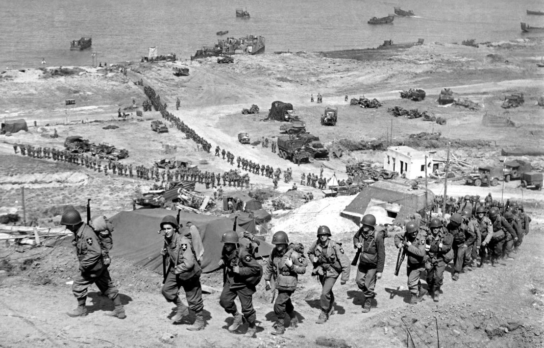 American troops march up from Omaha Beach on June 18, 1944.