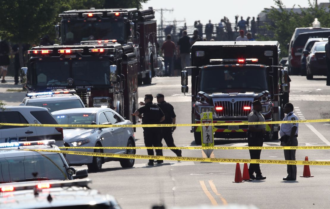 In this June 14, 2017 photo, investigators and emergency personnel gather adjacent to Eugene Simpson Field, the site where a gunman opened fire in Alexandria, Virginia.