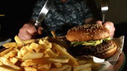 GLASGOW, UNITED KINGDOM - JUNE 07:  In this photo illustration a man eats a hamburger ind chips in a cafe on June 7,2006 in Glasgow, Scotland. New figures are suggesting that a large proportion of the population is clinically obese.  (Photo Illustration by Jeff J Mitchell/Getty Images)