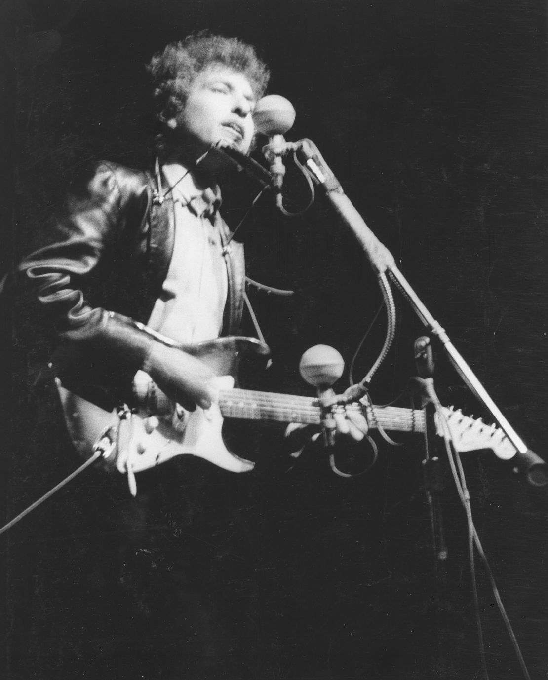 Bob Dylan playing an electric guitar on stage at the Newport Folk Festival in Newport, Rhode Island, on July 25, 1965.