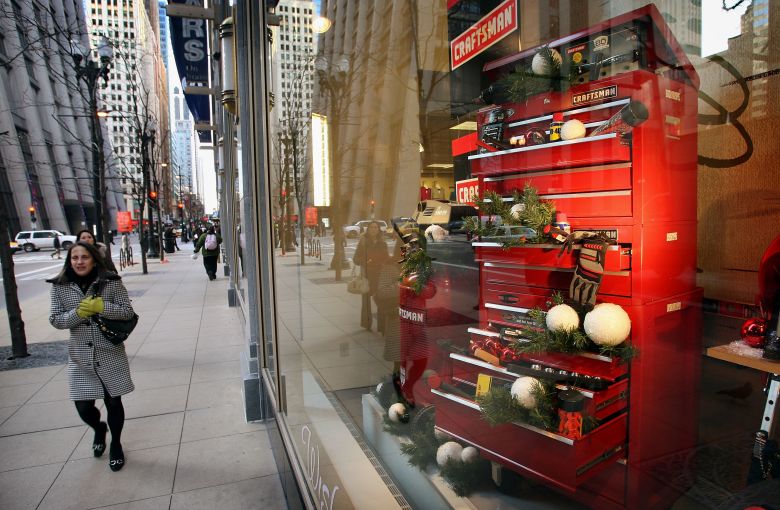 A pedestrian passes by a Craftsman tool display in the window of a Sears store on November 29, 2007 in Chicago, Illinois.