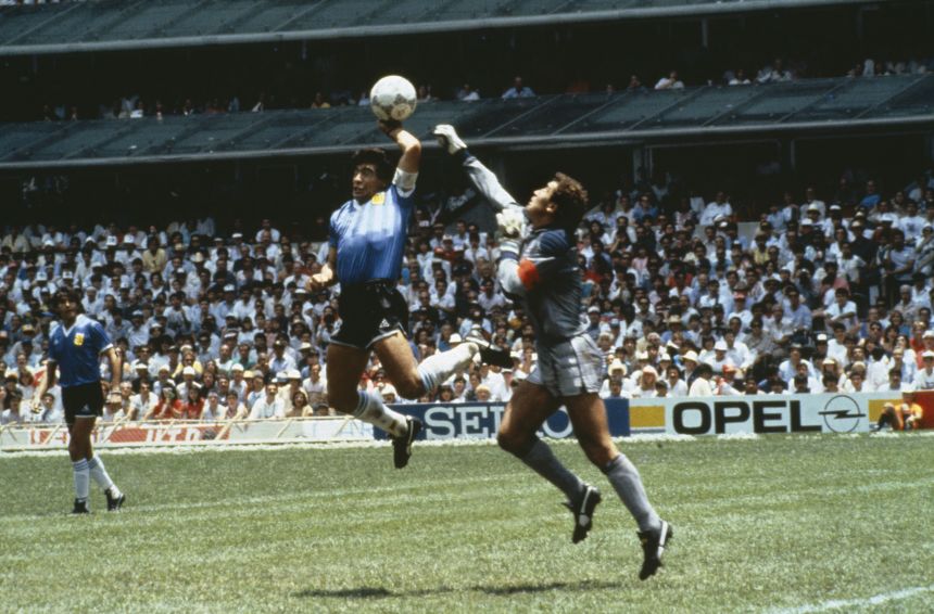 Diego Maradona scores the infamous "Hand of God" goal past England goalkeeper Peter Shilton.