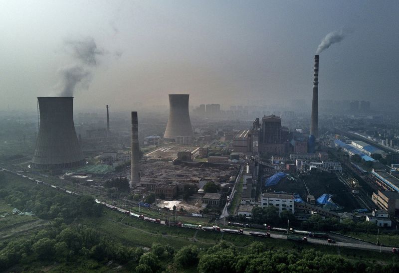 A coal fired power plant near a large floating solar farm project under construction on June 16, 2017 in Huainan, Anhui province, China.