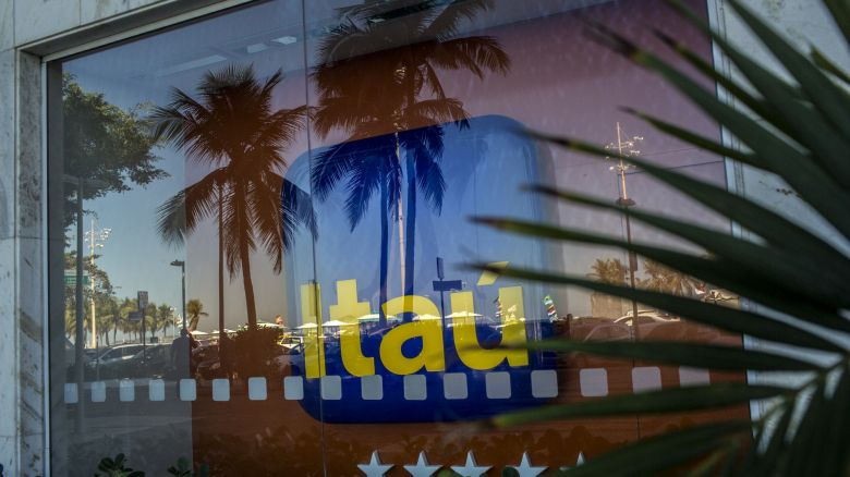 Palm streets are seen reflected in the window of an Itau Unibanco SA bank branch in Rio de Janeiro, Brazil, on Monday, July 31, 2017. Itau Unibanco SA is scheduled to release earnings figures on August 1. Photographer: Dado Galdieri/Bloomberg