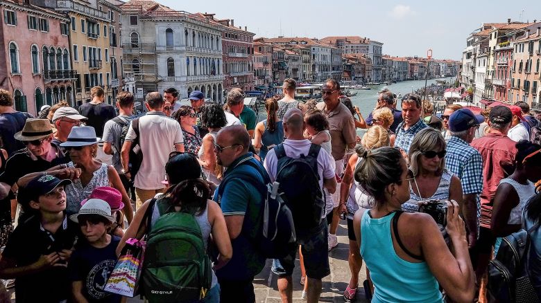 VENICE, ITALY - AUGUST 01:  A large crowd  of tourists stand on Rialto bridge on August 1, 2017 in Venice, Italy. Over 30 million tourists visit the 3 mile by 2 mile city of Venice each year with residents fearing that it can no longer cope with this volume of visitors.  There have been complaints about tourists bad behaviour including selfies being taking in areas where photography is prohibited, loitering on bridges, swimming in the canal and picnics in public places, all of which now carry a fine.  In an effort to avoid UNESCO placing Venice on their endangered list the city has announced new measures to preserve and protect the city.  (Photo by Stefano Mazzola/Awakening/Getty Images)