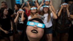 NEW YORK, NY - AUGUST 21:  People view the solar eclipse at 'Top of the Rock' observatory at Rockefeller Center, August 21, 2017 in New York City. While New York City is not in the path of totality for the solar eclipse, around 72 percent of the sun will be covered by the moon during the peak time of the partial eclipse. (Photo by Drew Angerer/Getty Images)