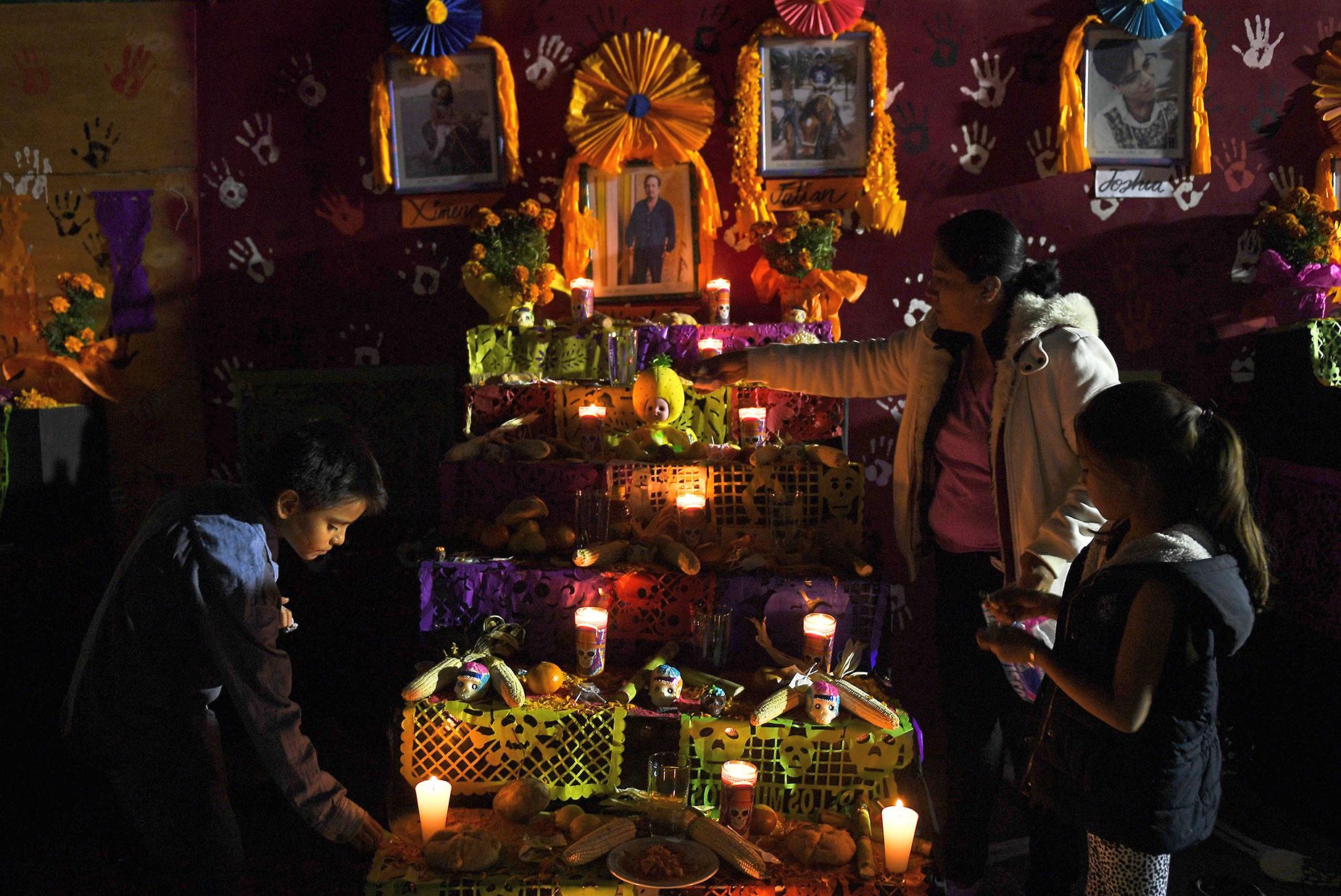 People gather in front of an altar to honor the victims of Mexico's September 19 earthquake, in the site of a collapsed building in Mexico City, on November 1, 2017.