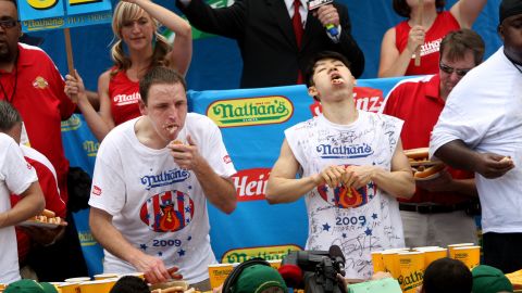 Joey Chestnut and Takeru Kobayashi stuff hot dogs into their mouths during Nathan's Famous Fourth of July hot dog eating contest in Coney Island in New York City, on July 4, 2009. Chestnut defeated Kobayashi with eating 68 to his 64.5 hotdogs.