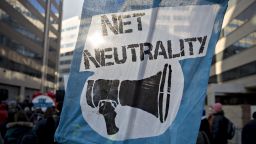 A demonstrator opposed to the roll back of net neutrality rules holds a sign outside the Federal Communications Commission (FCC) headquarters ahead of a open commission meeting in Washington, D.C., U.S., on Thursday, Dec. 14, 2017. The FCC is slated to vote to roll back a 2015 utility-style classification of broadband and a raft of related net neutrality rules, including bans on broadband providers blocking and slowing lawful internet traffic on its way to consumers.
