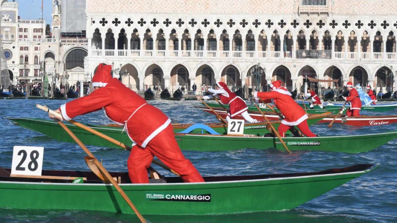 People dressed as Santa Claus take part in a regatta on the Grand Canal of Venice, on December 17, 2017.  / AFP PHOTO / ANDREA PATTARO        (Photo credit should read ANDREA PATTARO/AFP via Getty Images)