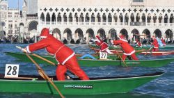 People dressed as Santa Claus take part in a regatta on the Grand Canal of Venice, on December 17, 2017.  / AFP PHOTO / ANDREA PATTARO        (Photo credit should read ANDREA PATTARO/AFP via Getty Images)