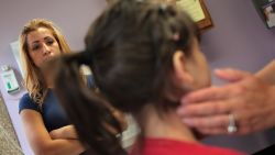 AURORA, CO - JULY 28:  Jessica Mejia (L) watches as her sick daughter Joselyn, age 4, is checked at a low-cost clinic run by the Rocky Mountain Youth Clinics on July 28, 2009 in Aurora, Colorado. The single mother of three said she has health insurance through her employer, but finds the clinic cheaper than paying the deductible to have her children cared for elsewhere. Funded primarily through donations and grants, Rocky Mountain Youth Clinics treats mostly children of uninsured parents, those on Medicaid and others whose parents cannot afford to pay the high deductibles charged by many health insurance policies. (Photo by John Moore/Getty Images)