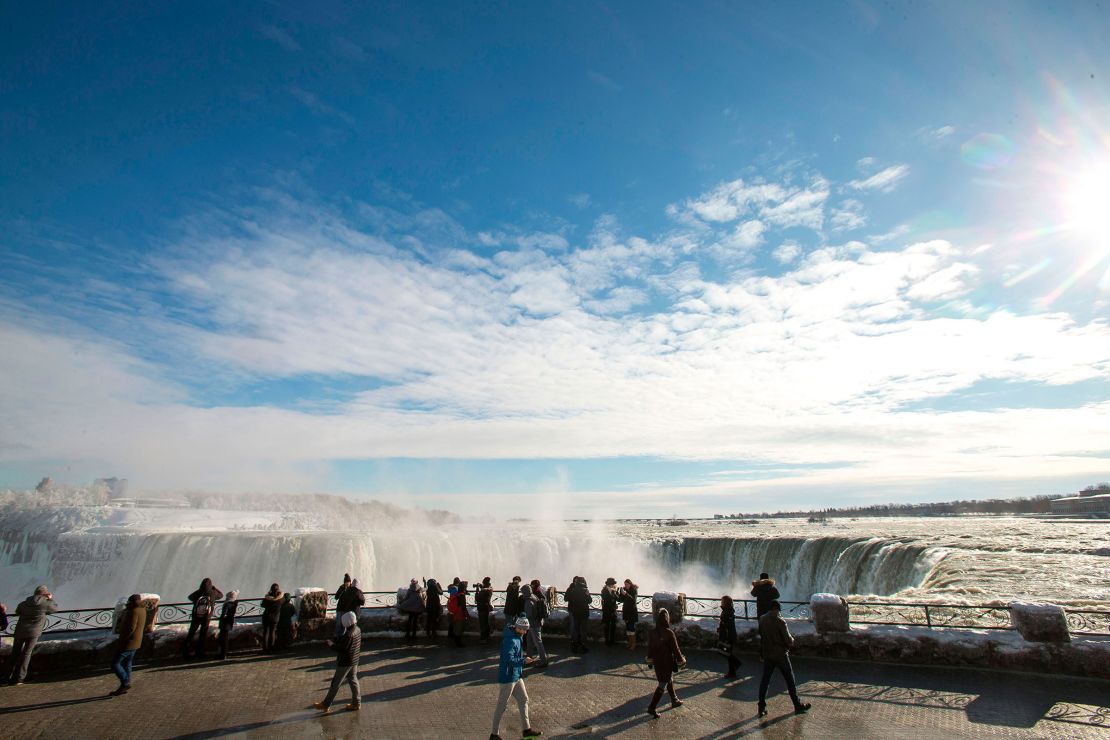 Tourists take photos of the Horseshoe Falls in Niagara Falls, Ontario on January 3, 2018. 