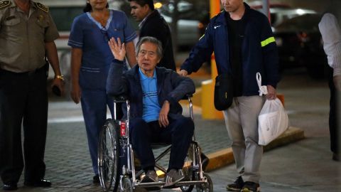 Peru's former President (1990-2000) Alberto Fujimori (C) waves to ers as he is wheeled out of the Centenario Clinic in Lima on January 04, 2018, where he was hospitalised for the last twelve days and where he received a Christmas' Eve pardon from President Kuczynski. - Fujimori was released from hospital late Thursday a free man following a controversial pardon by President Pedro Pablo Kuczynski. Aides rolled a frail-looking Fujimori out the main entrance of Lima's Centenario Clinic in a wheelchair, before he was whisked away in a convoy of vehicles. (Photo by LUKA GONZALES / AFP) (Photo by LUKA GONZALES/AFP via Getty Images)