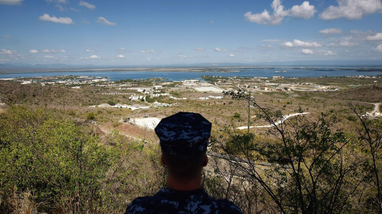 In this file image reviewed by the US military, a US Navy sailor looks out over the US Naval Base at Guantanamo Bay, Cuba.