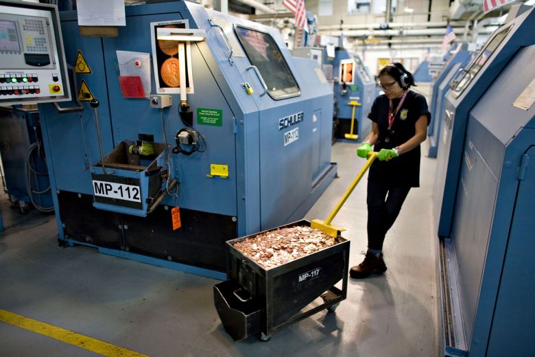 Press operator Syltham Smith carries a container of freshly minted pennies into the United States Mint in Denver in 2009.