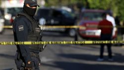 A police officer stands guard as state prosecutors inspect a pick-up truck found abandoned with the bodies of six men, some of them decapitated, which are though to have been killed by alleged traffickers of a rival cartel, in Morelos neighbourhood in Guadalajara, Mexico, on March 6, 2018. - Mexico has suffered a wave of violence linked to drug trafficking that has intensified in recent years. Authorities registered 25,339 murders in 2017, the most violent year since official data-keeping began in 1997. (Photo by ULISES RUIZ / AFP) (Photo by ULISES RUIZ/AFP via Getty Images)