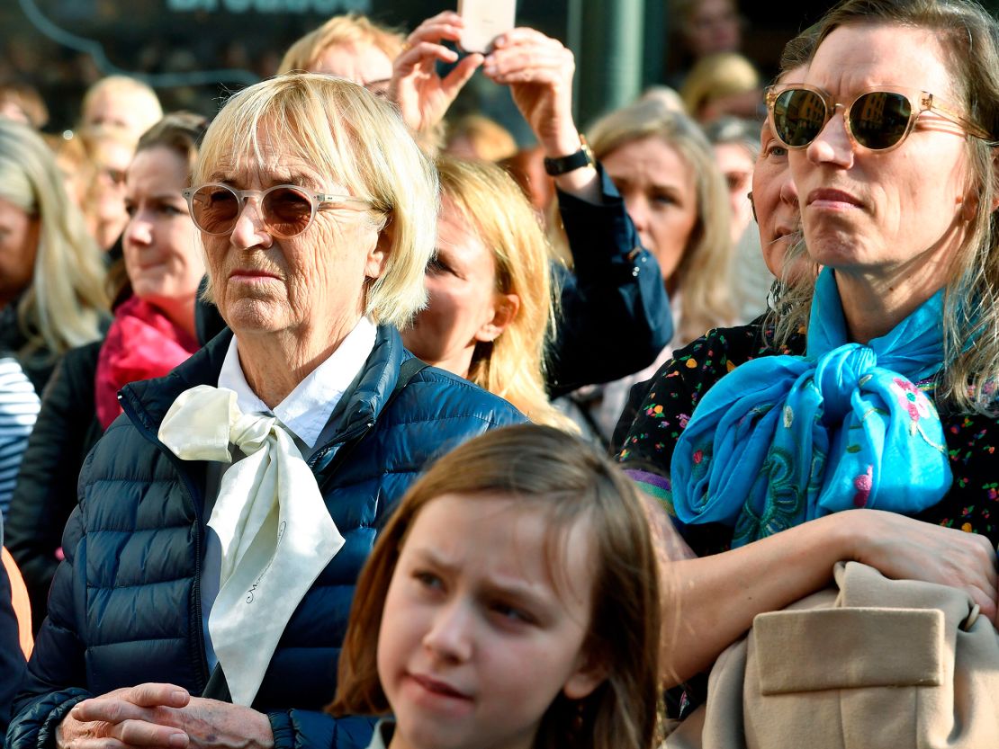 Orang-orang berkumpul di alun-alun Stortorget di Stockholm untuk menunjukkan dukungan kepada Sara Danius dengan mengenakan blus model pita dengan syal dan dasi leher.