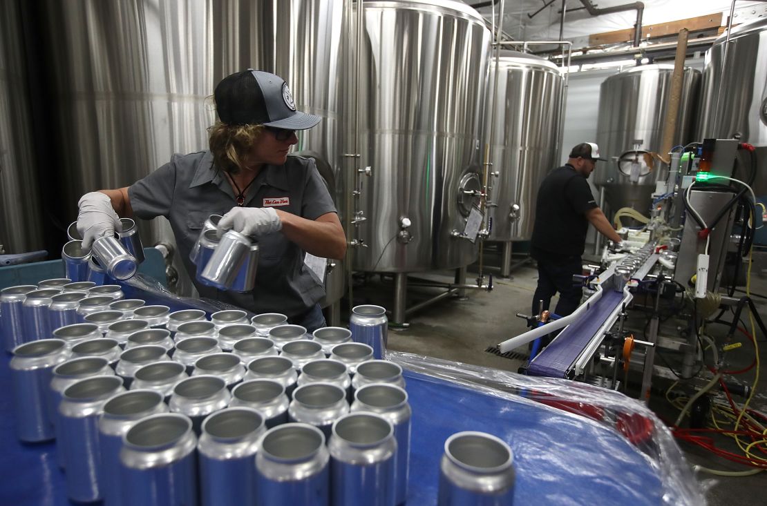 Empty aluminum cans are placed on a conveyor belt to be filled with beer at Devil's Canyon Brewery on June 6, 2018, in San Carlos, California.