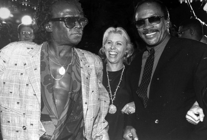 Jones poses for a photo with Miles Davis and Courtney Sale Ross in 1990.