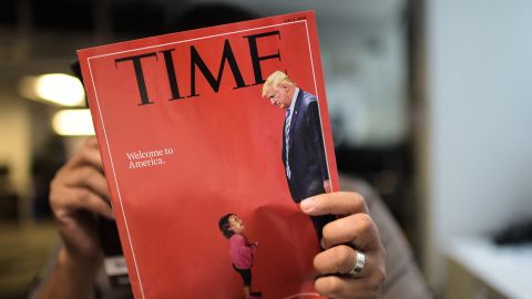 An AFP journalists reads a copy of Time Magazine with a front cover using a combination of pictures showing a crying child taken at the US Border Mexico and a picture of US President Donald Trump looking down, on June 22, 2018 in Washington DC.