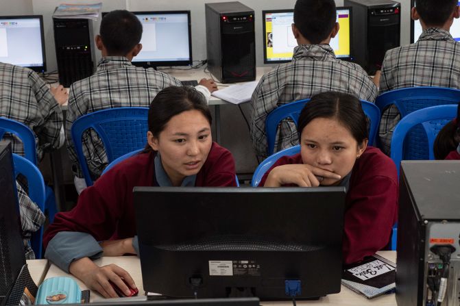 <strong>Classic and modern:</strong> Here, young people in traditional dress (kari for women and gho for young men) study computer science in a Bhutanese school.