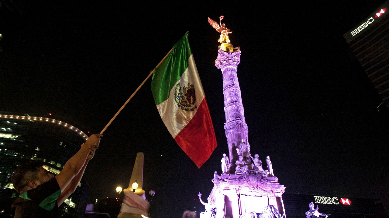 Supporters of the presidential candidate for the "Juntos haremos historia" coalition, Andres Manuel Lopez Obrador, celebrate at the Angel of Independence square in Mexico City, after getting the preliminary results of the general elections on July 2, 2018. Anti-establishment leftist Andres Manuel Lopez Obrador won Mexico's presidential election Sunday by a large margin, according to exit polls, in a landmark break with the parties that have governed for nearly a century. (Photo by Julio Cesar AGUILAR / AFP) (Photo by JULIO CESAR AGUILAR/AFP via Getty Images)