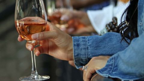 NEW ORLEANS, LA - JULY 08: A lady holds a glass of wine while on the balcony during the Starz Power Bruch at Cochon on July 8, 2018 in New Orleans, Louisiana. (Photo by Peter Forest/Getty Images for Starz)