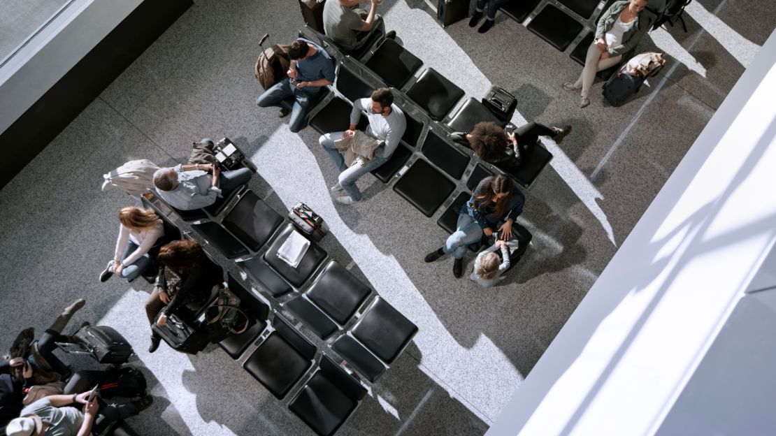 People wait in an airport at a departure lounge.