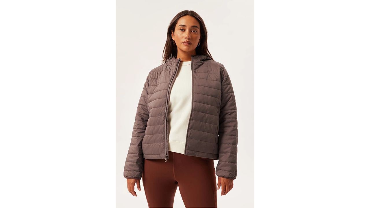 A photo of a person wearing the Girlfriend Collective Packable Puffer jacket