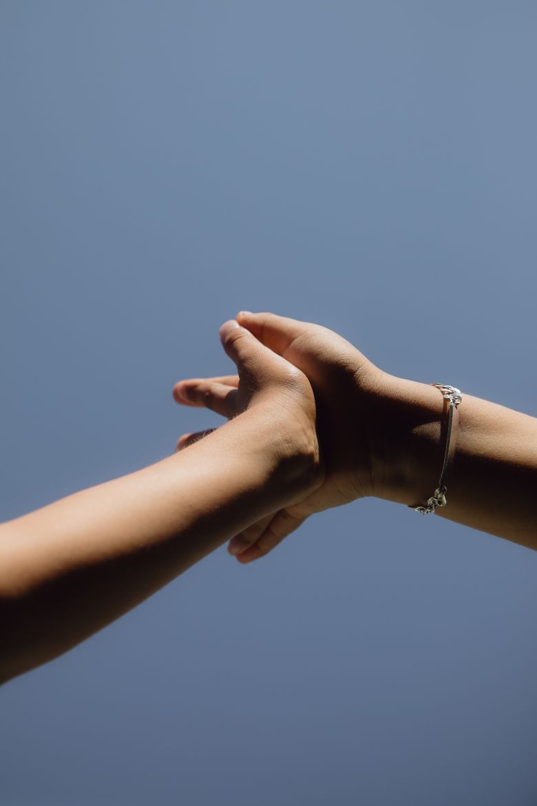 Siblings join hands while playing outside the apartment they've been staying at since their parents were deported.