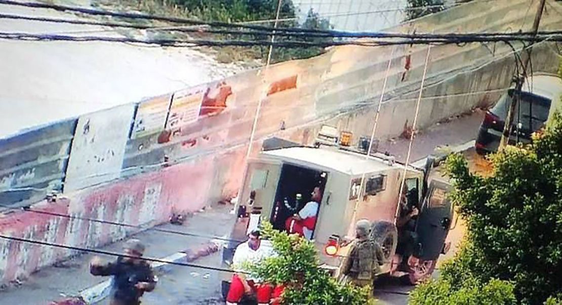 IDF soldiers detain an ambulance crew at the entrance of the Thabet Thabet hospital in Tulkarm, West Bank. The ambulance crew is seen siting inside an IDF vehicle while surrounded by soldiers.