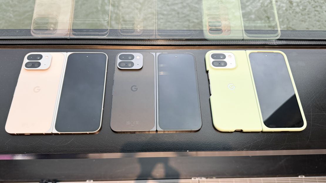 three Google Pixel 9 Pro Folds unfolded, in (L to R) porcelain white, obsidian black and a mint green cased option