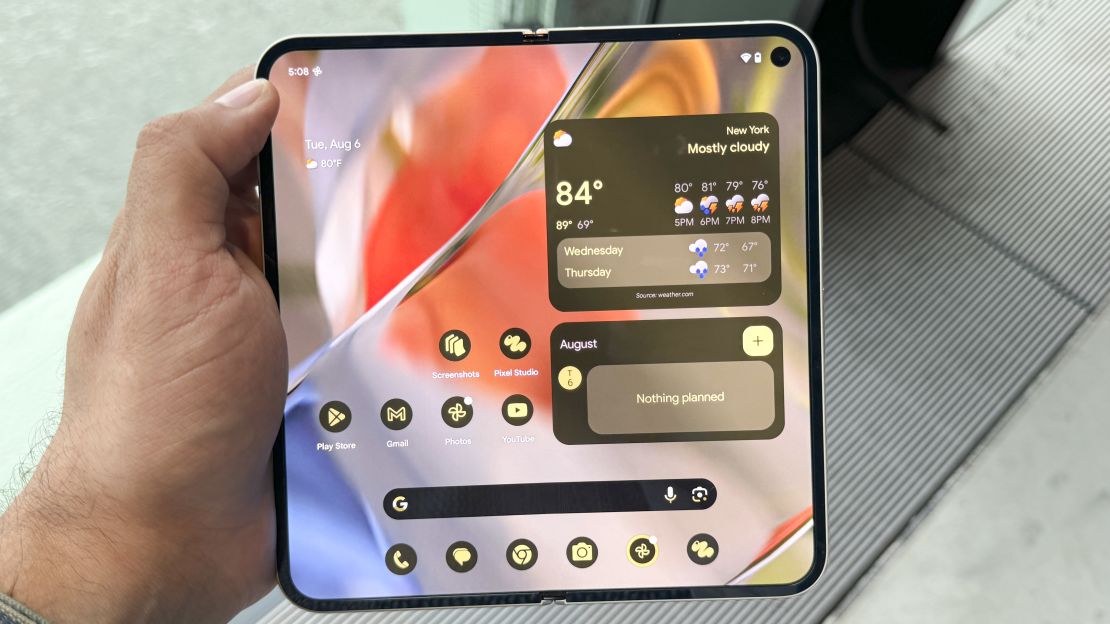 Google Pixel 9 Pro Fold held in hand, open to the home screen