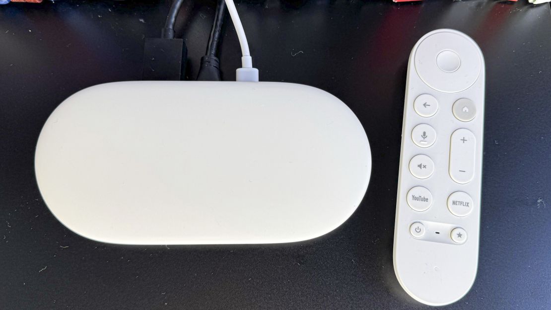 (L, R) the google tv streamer and its remote on a black surface