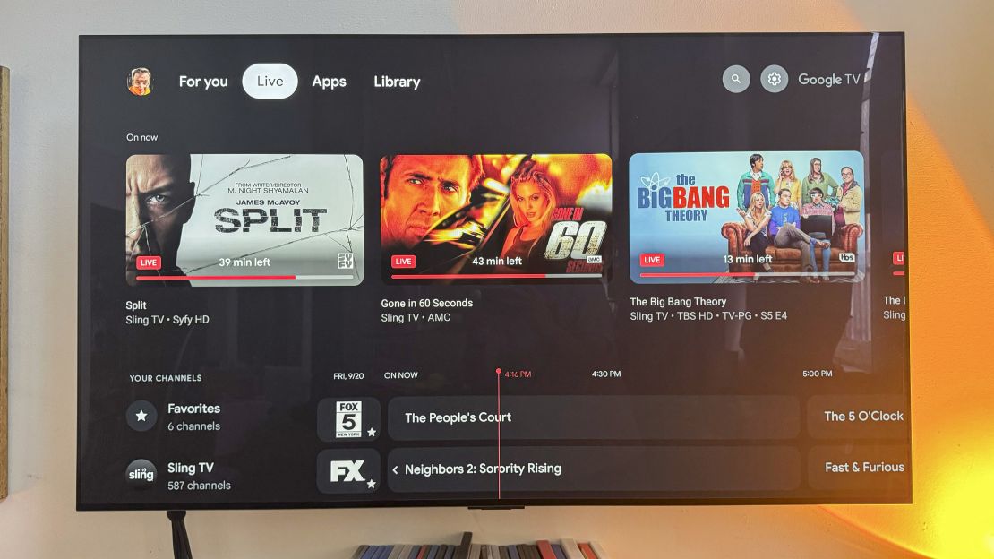 The Live section in Google TV shows Split, Gone in 60 Seconds and The Big Bang Theory are currently on right now, on a TV connected to the (not shown) Google TV Streamer